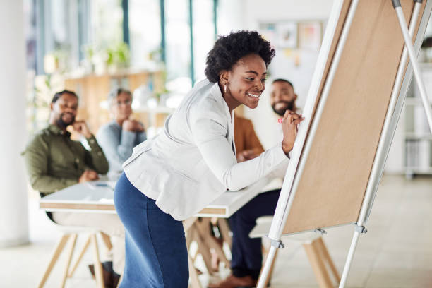 A black woman writing on a flip chart